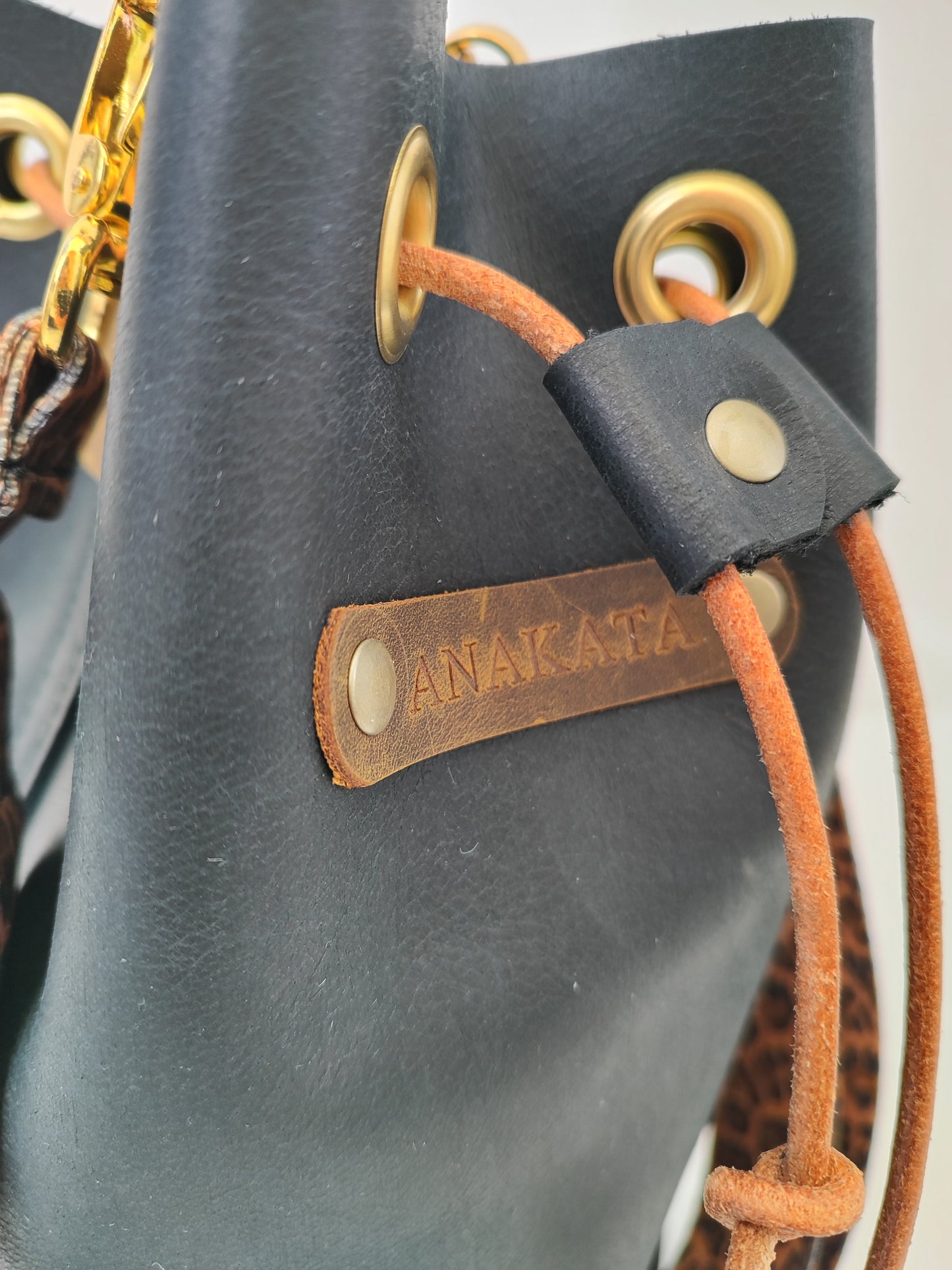 Χειροποίητη δερμάτινη τσάντα πουγκί - μαύρο με καφέ και χρυσές λεπτομέρειες και λεοπάρ ιμάντα.