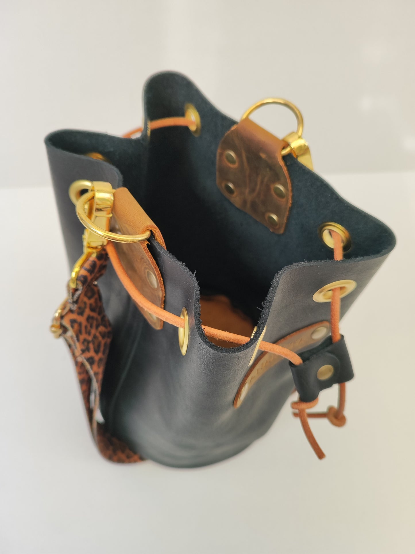 Χειροποίητη δερμάτινη τσάντα πουγκί - μαύρο με καφέ και χρυσές λεπτομέρειες και λεοπάρ ιμάντα.